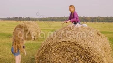 女孩正试图爬上干草堆，找朋友坐在上面帮助她。